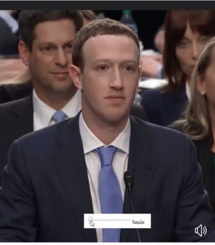 A Man In A Suit And Tie Is Smiling While Sitting At A Microphone GIF