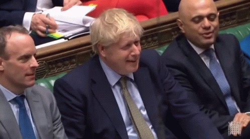 A Man In A Suit And Tie Is Smiling While Sitting Next To Two Other Men In Suits And Ties GIF