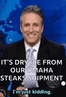 A Man In A Suit And Tie Is Smiling While Talking About Dry Ice From Omaha Steaks Shipment . GIF