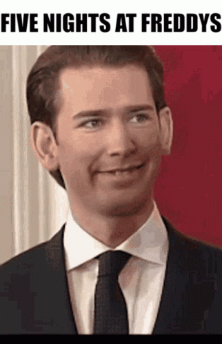 A Man In A Suit And Tie Is Smiling With The Words Five Nights At Freddys Below Him GIF