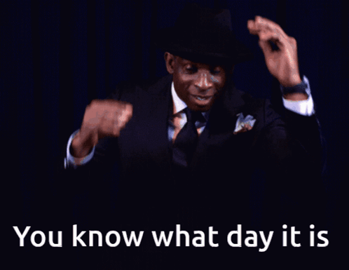 A Man In A Suit And Tie Is Smiling With The Words " You Know What Day It Is " Below Him GIF