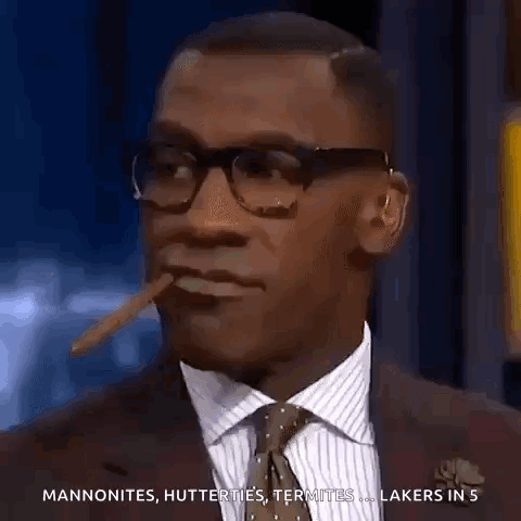 A Man In A Suit And Tie Is Smoking A Cigar And Talking About The Lakers GIF