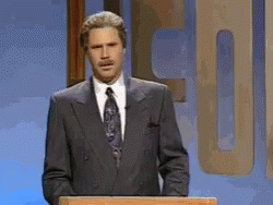 A Man In A Suit And Tie Is Standing Behind A Podium GIF