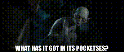 A Man In A Suit And Tie Is Standing In A Cave And Asking What Has It Got In Its Pockets ? GIF
