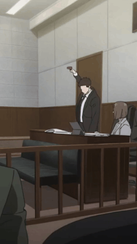 A Man In A Suit And Tie Is Standing In A Courtroom Holding Up A Gun GIF