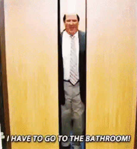 A Man In A Suit And Tie Is Standing In A Doorway With The Words `` I Have To Go To The Bathroom ! '' GIF