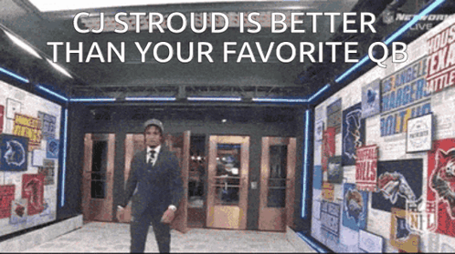 A Man In A Suit And Tie Is Standing In A Hallway With A Sign That Says Cj Stroud GIF