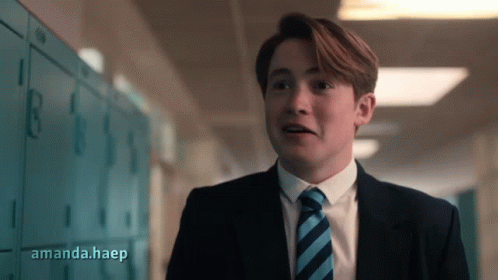 A Man In A Suit And Tie Is Standing In A Hallway With Amanda.haep Written On The Bottom Right GIF