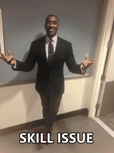 A Man In A Suit And Tie Is Standing In A Hallway With The Words Skill Issue Written Below Him GIF