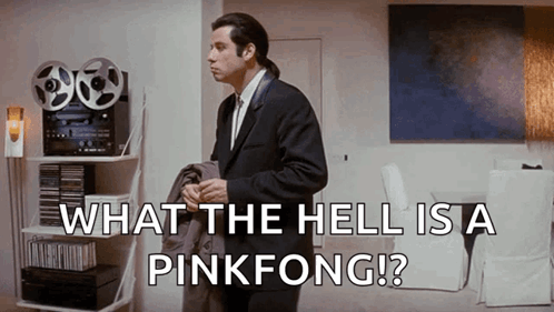 A Man In A Suit And Tie Is Standing In A Living Room With The Words What The Hell Is A Pinkfong .. GIF