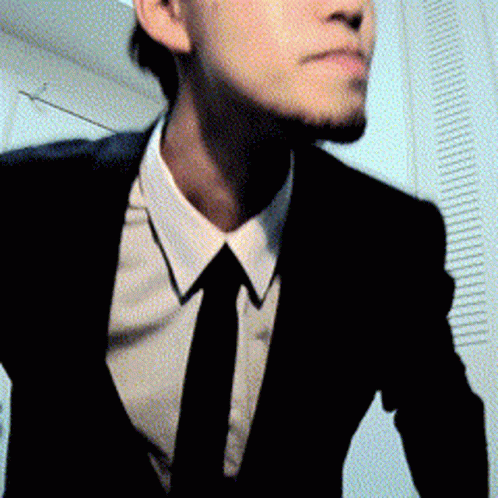 a man in a suit and tie is standing in a room