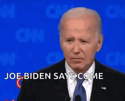 A Man In A Suit And Tie Is Standing In Front Of A Blue Background And Says `` Joe Biden Says Come '' . GIF