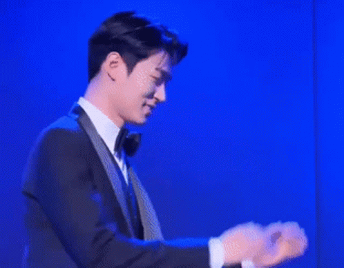 Man In Suit And Tie In Front Of Blue Background GIF