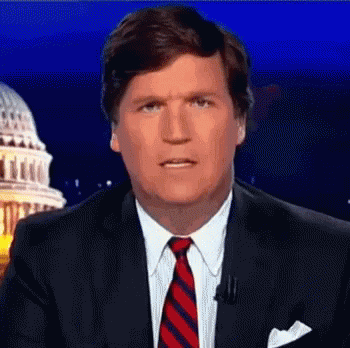 A Man In A Suit And Tie Is Standing In Front Of A Capitol Building . GIF