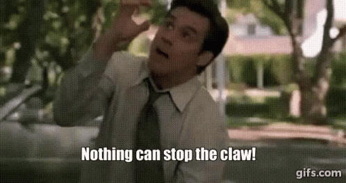 A Man In A Suit And Tie Is Standing In Front Of A Car And Says Nothing Can Stop The Claw . GIF