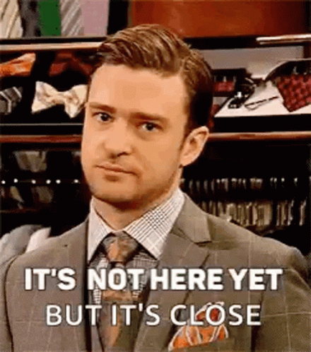 A Man In A Suit And Tie Is Standing In Front Of A Closet And Making A Funny Face . GIF