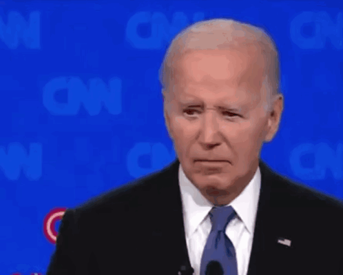 A Man In A Suit And Tie Is Standing In Front Of A Cnn Logo GIF