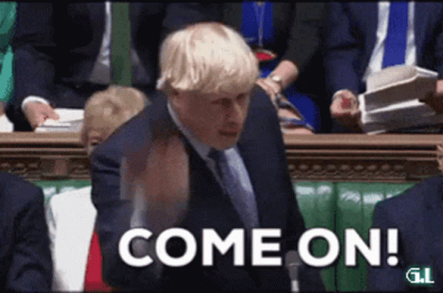 A Man In A Suit And Tie Is Standing In Front Of A Crowd And Says Come On GIF