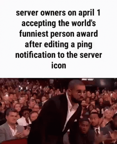 A Man In A Suit And Tie Is Standing In Front Of A Crowd Of People . GIF