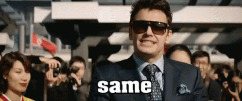A Man In A Suit And Tie Is Standing In Front Of A Crowd With The Word Same Written On The Screen . GIF