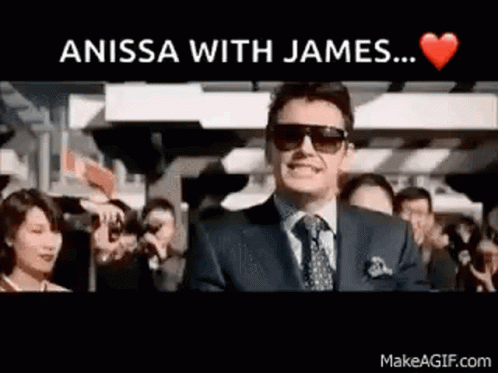 A Man In A Suit And Tie Is Standing In Front Of A Crowd With The Words " Anissa With James ... " Above Him GIF