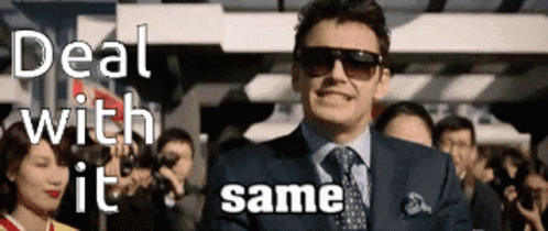 A Man In A Suit And Tie Is Standing In Front Of A Crowd With The Words Deal With It Same GIF
