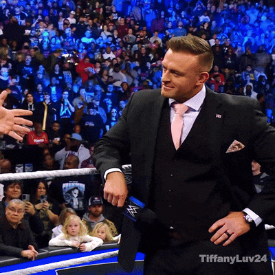 A Man In A Suit And Tie Is Standing In Front Of A Crowd With Tiffanyluv24 Written On The Bottom GIF