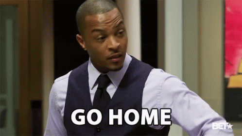 A Man In A Suit And Tie Is Standing In Front Of A Door And Saying `` Go Home '' . GIF