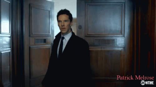 a man in a suit and tie is standing in front of a door that says patrick melrose showtime on it