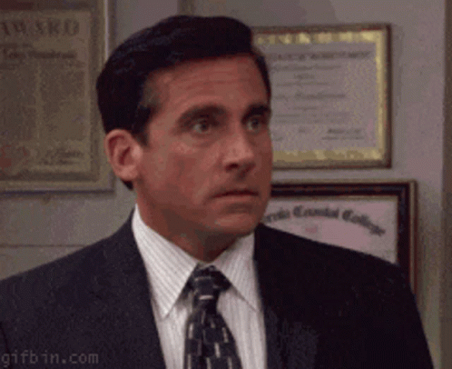 A Man In A Suit And Tie Is Standing In Front Of A Framed Certificate That Says ' Award ' On It GIF