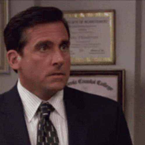 A Man In A Suit And Tie Is Standing In Front Of A Framed Diploma That Says Essential College GIF
