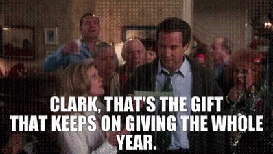 A Man In A Suit And Tie Is Standing In Front Of A Group Of People . GIF