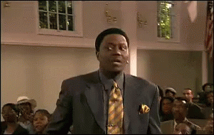 A Man In A Suit And Tie Is Standing In Front Of A Group Of People In A Church . GIF