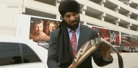 A Man In A Suit And Tie Is Standing In Front Of A Limousine Holding A Newspaper . GIF