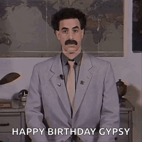 A Man In A Suit And Tie Is Standing In Front Of A Map And Saying Happy Birthday Gypsy . GIF