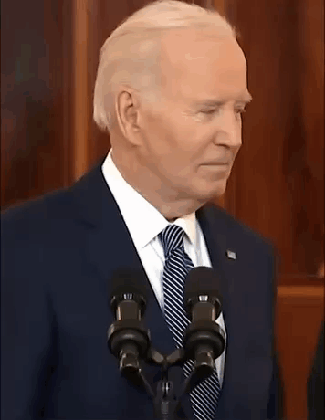 A Man In A Suit And Tie Is Standing In Front Of A Microphone With The Words Is That A Joke Written Below Him GIF