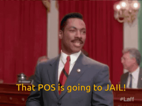 A Man In A Suit And Tie Is Standing In Front Of A Red Curtain And Says That Pos Is Going To Jail GIF