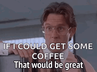 A Man In A Suit And Tie Is Standing In Front Of A Refrigerator And Talking About Coffee . GIF