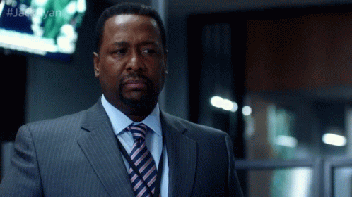 A Man In A Suit And Tie Is Standing In Front Of A Screen That Says #Jackryan GIF
