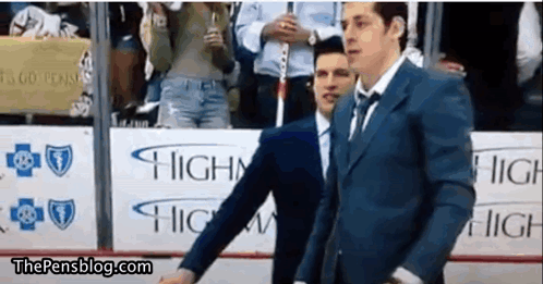 a man in a suit and tie is standing in front of a sign that says highway .