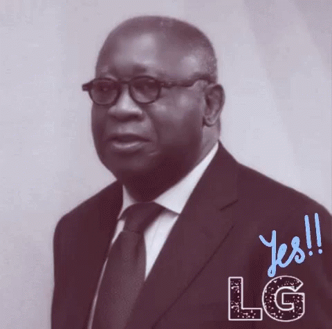 A Man In A Suit And Tie Is Standing In Front Of A Sign That Says Lg GIF