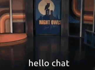 A Man In A Suit And Tie Is Standing In Front Of A Sign That Says Night Owl . GIF