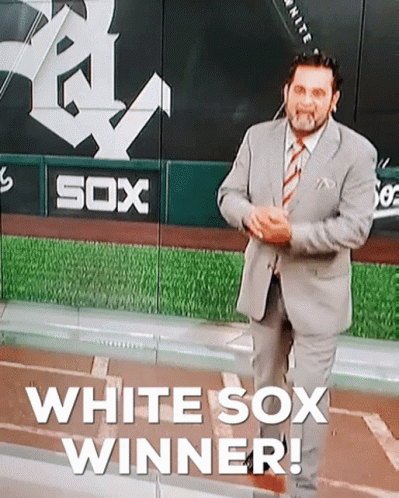 A Man In A Suit And Tie Is Standing In Front Of A Sign That Says Sox GIF