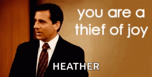 A Man In A Suit And Tie Is Standing In Front Of A Sign That Says `` You Are A Thief Of Joy Heather '' GIF