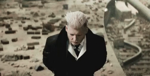 A Man In A Suit And Tie Is Standing In Front Of A Train Track . GIF