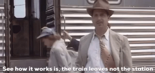 Man In Suit And Tie Standing In Front Of Train GIF