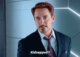 A Man In A Suit And Tie Is Standing In Front Of A Wall And Saying `` Kidnapped ? '' GIF