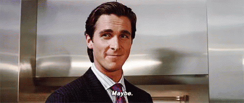 A Man In A Suit And Tie Is Standing In Front Of A Wall And Saying `` Maybe '' . GIF