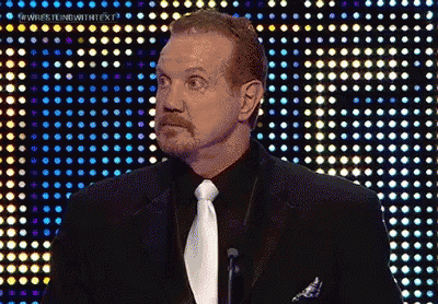 A Man In A Suit And Tie Is Standing In Front Of A Wall Of Lights GIF
