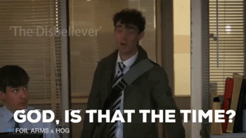 A Man In A Suit And Tie Is Standing In Front Of A Window And Says God Is That The Time GIF